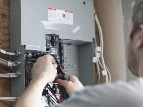 An electrician upgrading an electrical panel