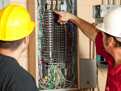 Electricians inspecting panel