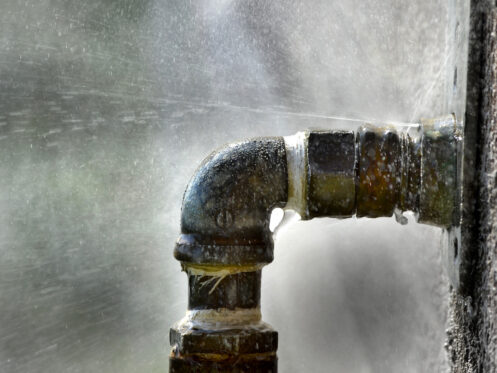 An old, rusty leaking pipe outside a home in Bellingham